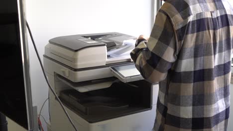 Dokumentdruckkonzept:-Geschäftsmann-Arrangiert-Papiere-Vor-Dem-Bedienfeld-Des-Laserdruckers-Für-Kopierscanner-Und-Dokumentdruckberichtsdiagramm-In-Einem-Geschäftigen-Büro