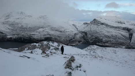 hiker-climbing-snowy-mountain,-Torridon,-Scotland