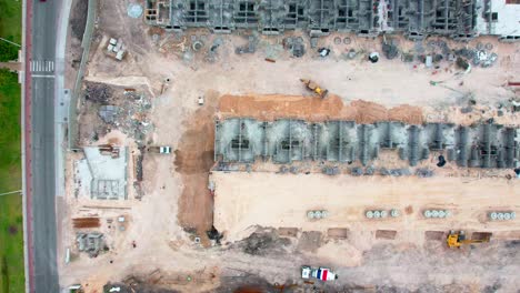 Aerial-hyperlapse-heavy-machinery-working-directly-above-a-construction-site