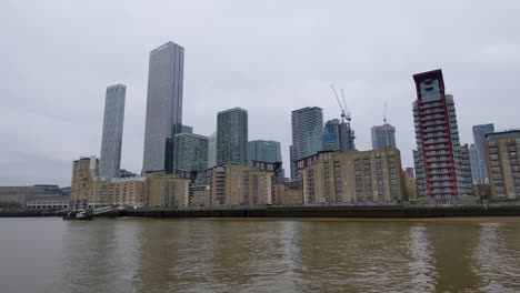 Canary-Wharf-in-a-gloomy-London,-taken-from-a-boat-on-the-river-Thames