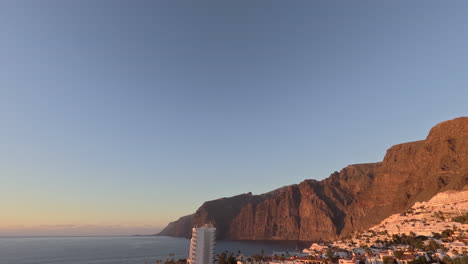 Sunset-Timelapse-of-Los-Gigantes-Cliffs-in-Tenerife-on-a-Clear-Day-with-the-City-Lights-Illuminating
