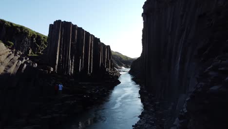 A-Bru-river-in-Studlagil-Canyon,-Iceland-with-basalt-rock-columns,-front-view,-moving-in