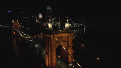 Aerial-Night-Pan-of-Suspension-Bridge-and-Downtown-Cincinnati,-Ohio