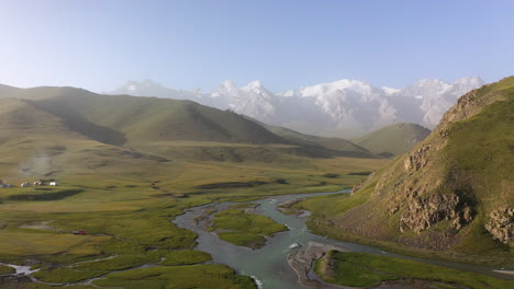 Wide-drone-shot-of-a-Yurt-campsite-near-the-Kurumduk-river-in-Kyrgyzstan,-rotating-aerial-shot