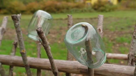 Glass-jars-are-drying-on-the-fence-of-the-hayloft