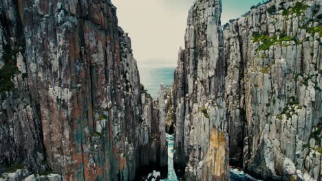 Cape-Hauy-Drone-Flys-in-Between-Sea-Cliffs-in-Tasmania,-Australia