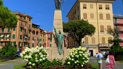Tourists-walking-by-Monument-Vittorio-Emanuele-statue,-Santa-Margherita,-Italy