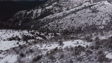 Wonderful-aerial-drone-view-going-down-steep-snow-white-mountain,-wild-landscape
