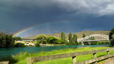 Historical-bridge,-Alexandra,-New-Zealand-with-storm-clouds-and-rainbow