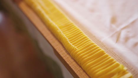 Close-up-shot-of-a-bunch-of-Italian-handmade-pasta-over-a-raw-wood-chopping-board