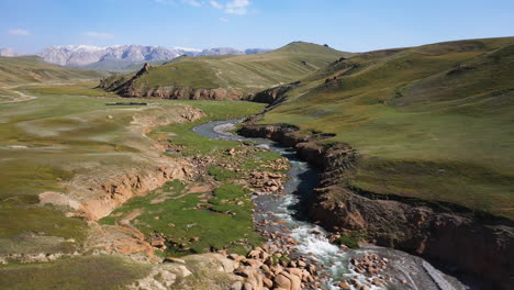 Aerial-drone-shot-going-through-a-crevasse-near-the-Kel-Suu-lake-in-Kyrgyzstan,-wide-shot