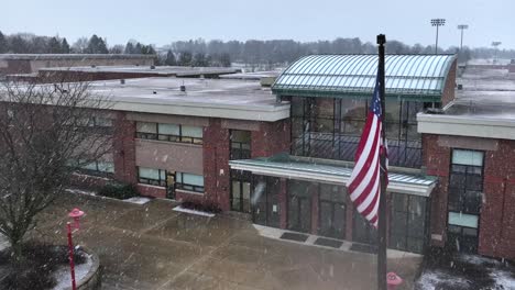 American-flag-waving-in-front-of-high-school-during-snow-storm