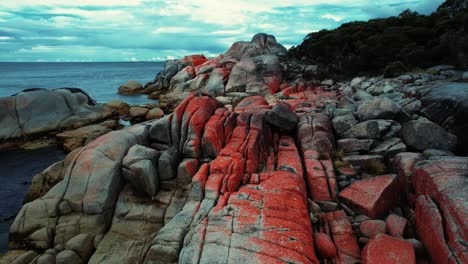 Bay-Of-Fires-Drone-Flys-Low-Through-Orange-Boulders-Tasmania