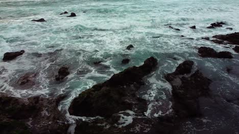 Revealing-shot-of-the-ocean-in-canary-island,-starting-with-black-rocks