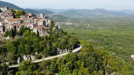 Beautiful-aerial-shot-of-a-rented-car-driving-around-Roccaravindola-hilltop-old-town-in-Molise-region-of-Italy