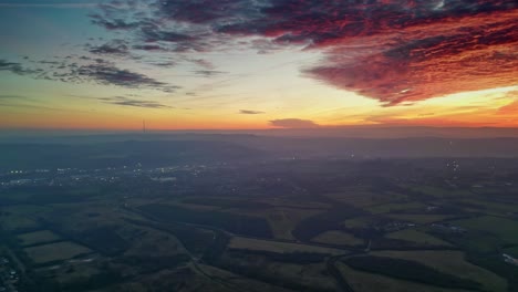 Drone-Filmische-Landschaft-Landschaft-Grün-Neblige-Felder-Bunt-Rot-Lodernder-Sonnenuntergang-Horizont-Feurige-Wolken