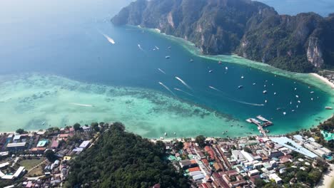 Vista-Aérea-Sobre-La-Playa-De-Ton-Sai-En-Koh-Phi-Phi,-Krabi-Tailandia-Con-Barcos-Que-Van-Y-Vienen