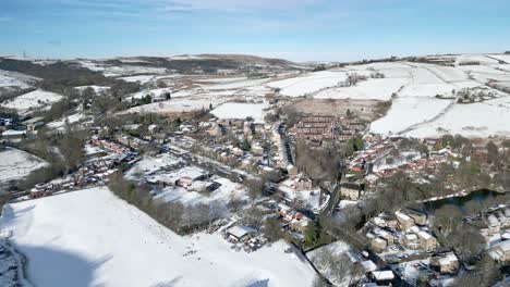 Cold-Snowy-Winter-Cinematic-aerial-view-cityscape-townscape-with-snow-covered-roof-tops-Panorama-4K-Delph-Village-West-Yorkshire,-Endland