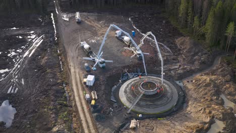 Pouring-of-a-concrete-footing-for-a-mega-structure-foundation-in-the-middle-of-a-forest,-wind-turbine-construction-process