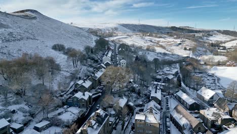 Cold-Snowy-Winter-Cinematic-aerial-view-cityscape-townscape-with-snow-covered-roof-tops-Panorama-small-rural-town-of-Delph-Village-West-Yorkshire,-England