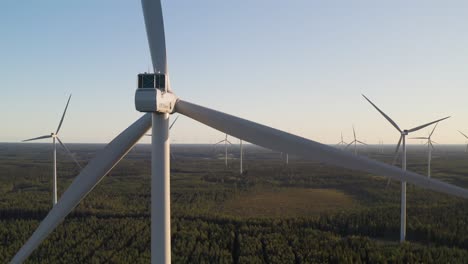 Back-view-of-a-wind-turbine-producing-energy-at-a-wind-farm,-scenic-landscape-shot