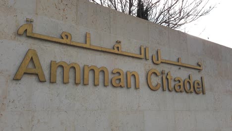 Amman-Citadel-welcome-sign-to-the-historical,-popular-tourism-ruins-in-the-Capital-city-of-Jordan,-written-in-English-and-Arabic