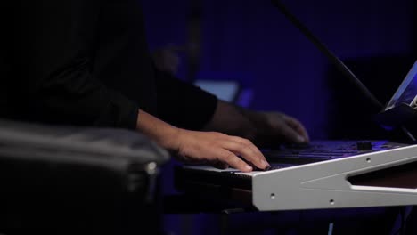 balkan-music-artist-playing-synth-fast-at-concert-indoors,-close-up-of-hand-on-keys