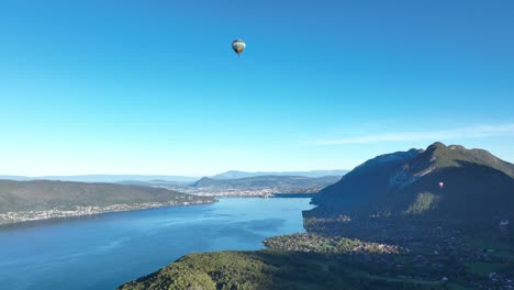 Hot-air-balloon-flying-low-over-Annecy-lake-in-a-summer-morning
