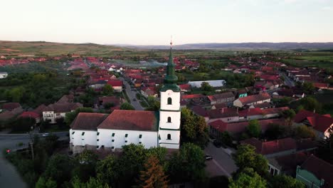 Aerial-orbit-view-of-hungarian-medieval-protestant-church-in-a-green-village
