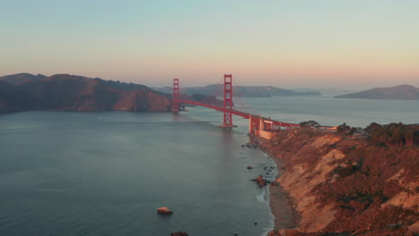 Wide-descending-aerial-shot-of-the-Golden-Gate-bridge-at-sunset