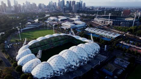 Aerial-Melbourne-park-stadium-shaped-like-a-football,-sports-stadium