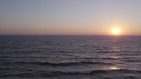 Gorgeous-Orange-and-Pink-Sunset-in-Oxnard,-California---4K-Drone-Flight-over-Ocean-at-Sunset-short-shot