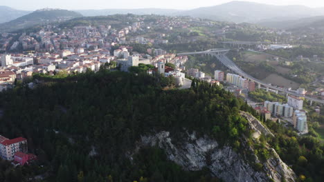 Wide-aerial-orbiting-shot-of-Monforte-Castle-in-Campobasso-with-city-in-the-background