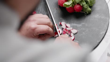 Chef-cuts-radish-on-a-slate-board-to-prepare-cebiche