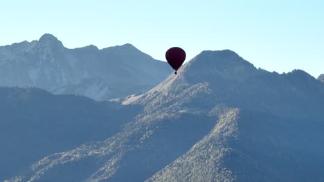 Heißluftballon-Mit-Berggipfeln-Im-Hintergrund-In-Den-Alpen