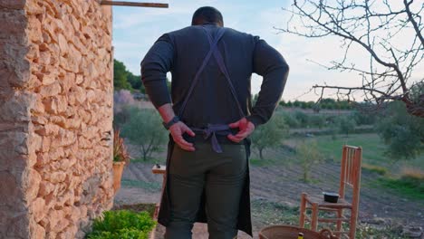 Man-cook-ties-his-apron-behind-his-back-is-a-Mediterranean-landscape