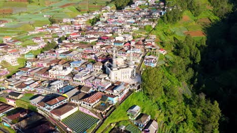 Drone-shot-of-Beautiful-rural-landscape-and-mosque-with-2-minarets-located-on-the-slope-of-Mount-Sumbing,-Indonesia---Baituttaqwa-mosque-on-Nepal-Van-Java,-Indonesia