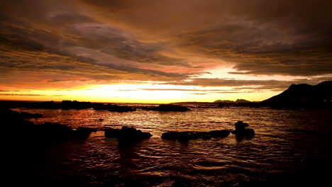 Sky-on-fire-after-sunset,-vibrant-orange-clouds-golden-hour,-ocean-reflection