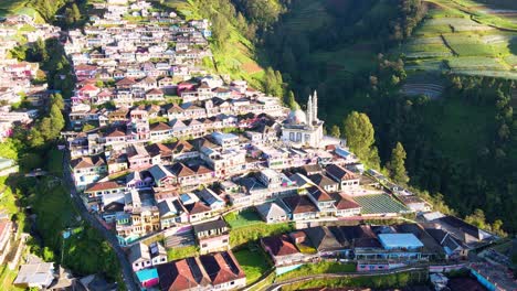 Drone-shot-of-Beautiful-village-and-mosque-with-2-minarets-located-on-the-slope-of-Mount-Sumbing,-Indonesia---Baituttaqwa-mosque-on-Nepal-Van-Java,-Indonesia