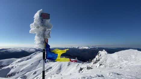 Zerrissene-Flagge-Weht-Im-Winter-Auf-Dem-Ciucas-Gipfel-Aus-Rumänien-Durch-Den-Wind
