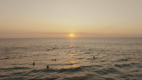 Menschen-Im-Ozean-Bei-Sonnenuntergang-In-Guanacaste,-Costa-Rica---Luftdrohnenaufnahme