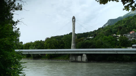 Handheld-Shot-of-the-River-the-Inn-Flowing-Under-the-Neue-Hungerburgbahn-Bridge-in-Innsbruck,-Austria