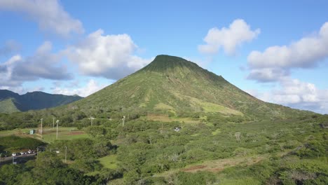 Aerial-Dolly-Aufstieg-Eines-Großen-Berges-In-Hawaii-Kai-Honolulu-An-Einem-Blauen-Himmelstag-Mit-Flauschigen-Wolken-Und-Einem-Baseballfeld-Im-Blick
