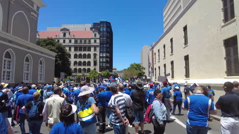 A-large-crowd-of-protestors-listen-to-a-political-speech-about-Eskom's-load-shedding-and-rolling-blackouts