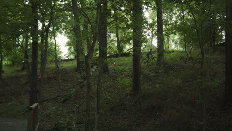wide-shot-of-two-bicyclists-riding-through-the-forest