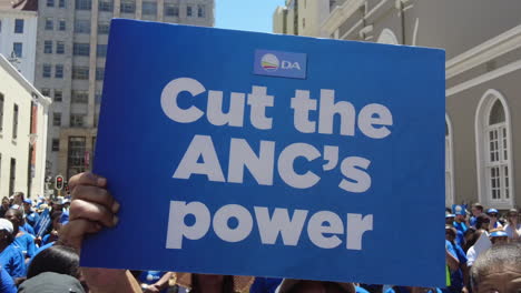 A-woman-holds-up-a-sign-protesting-the-ANC-and-Eskom's-load-shedding-and-rolling-blackouts