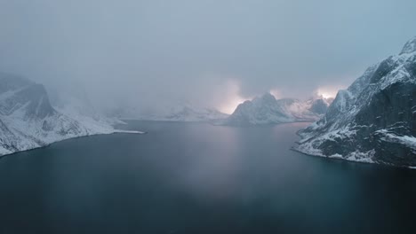 Montañas-Cubiertas-De-Nieve-En-Reine,-Islas-Lofoten,-Noruega-Al-Atardecer-Con-Nubes-Azul-Oscuro