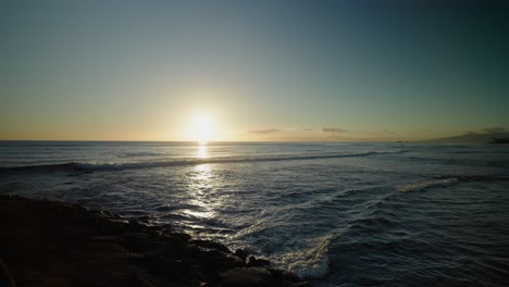 Hawaiianischer-Sonnenuntergang-Mit-Paddelboarder,-Der-Durch-Wellen-In-Den-Rahmen-Paddelt