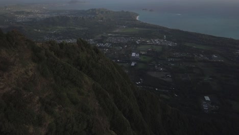Slow-aerial-pullback-tilt-over-Hawaii-Kai-Honolulu-in-the-early-morning-over-the-mountains-revealing-the-pacific-ocean