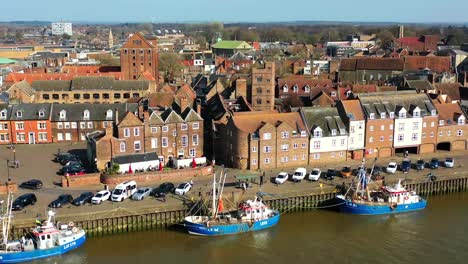 Aerial-view-of-Kings-Lynn-riverfront,-three-fishing-trawlers-and-the-River-Great-Ouse,-Kings-Lynn,-Norfolk,-UK
